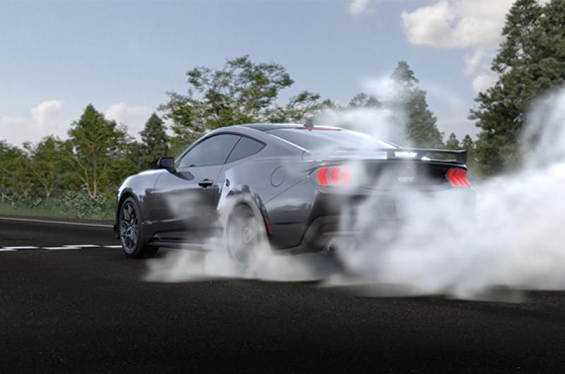 A computer-generated image of a Mustang® Coupe burning rubber on a drag strip.