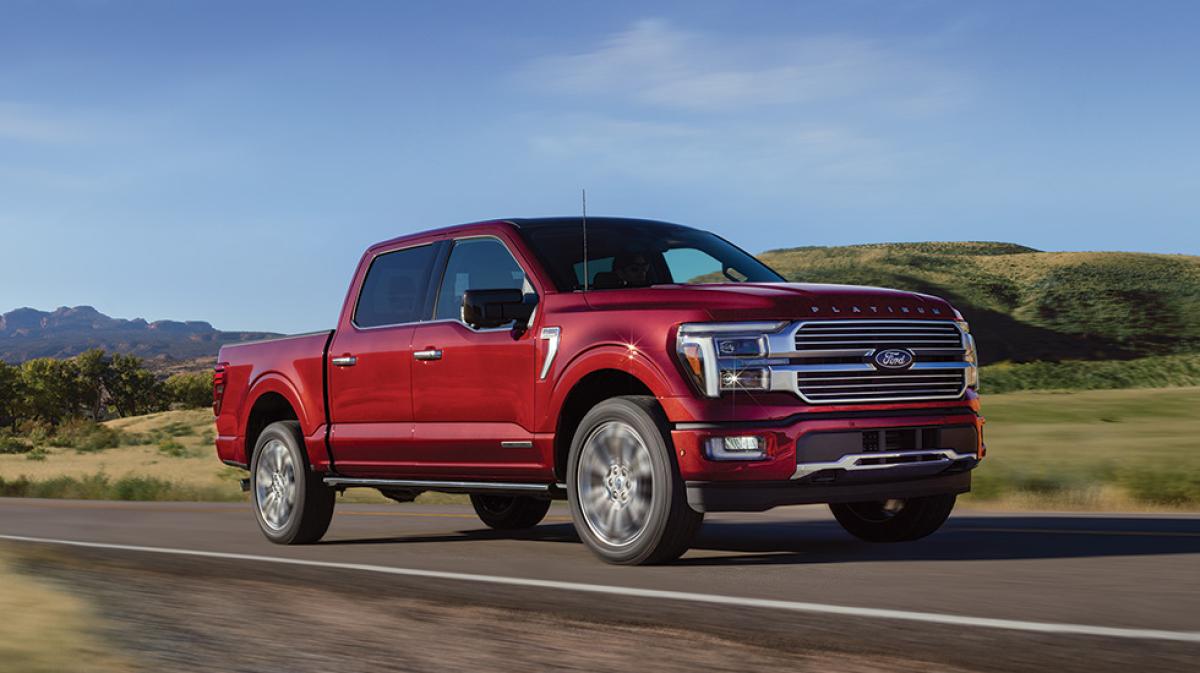 A Platinum® F-150® pickup powers along a country road.